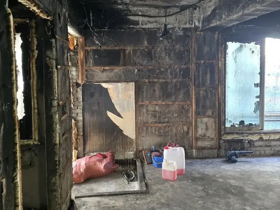 완전히 그을린 어두운 실내와 바닥에 흩어진 자재 — 학원 교실 화재청소 그을음 제거
