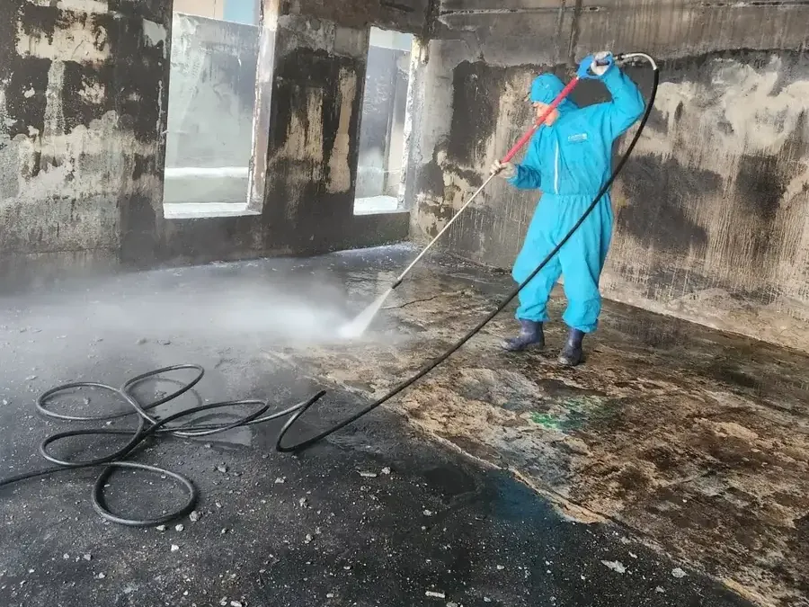 작업 공정 3단계 그을음 세척·약품 처리: 고압 세척기로 물을 뿌리며 벽과 천장을 세척하는 작업자 — 어린이집 화재청소 유아시설 안전청소